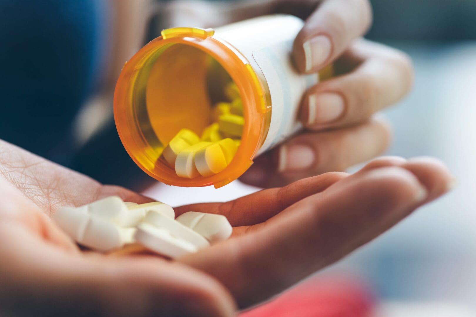 Person dispensing medication from bottle