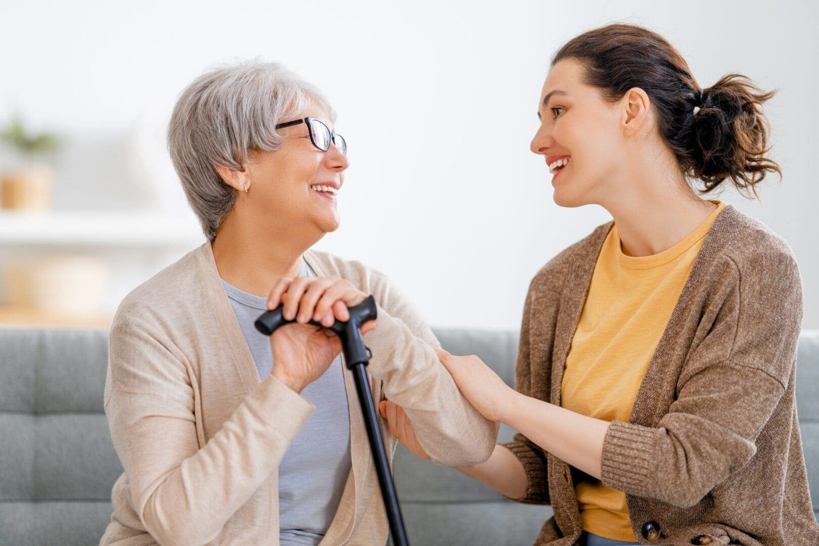 Elderly woman and caregiver smiling together